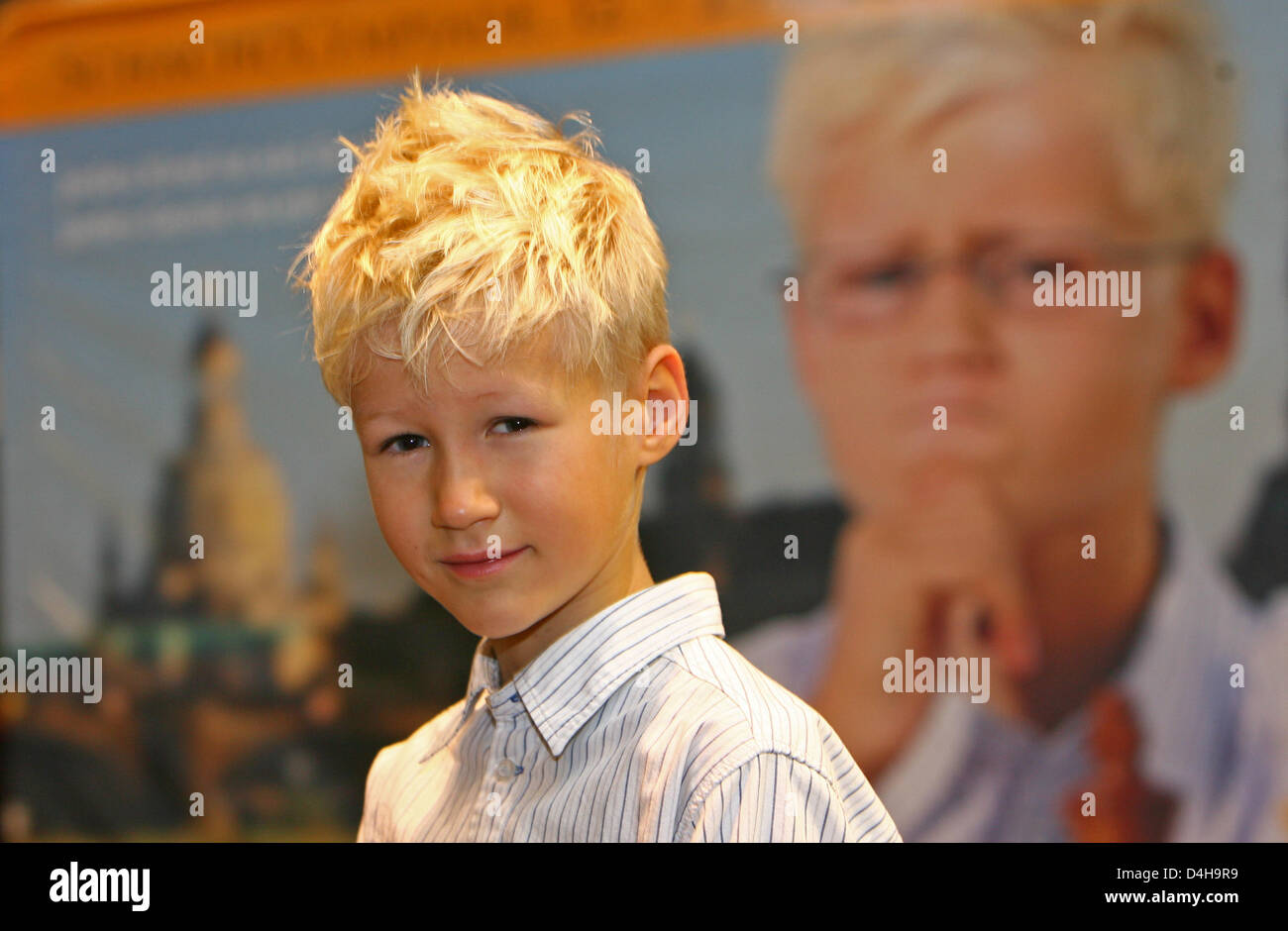 Eight-year-old Tim Wagner stands in front of ?his? poster and smiles during  the 2008 Chess Olympiad in Dresden, Germany, 15 November 2008. His is one  of the face represented during the advertisement