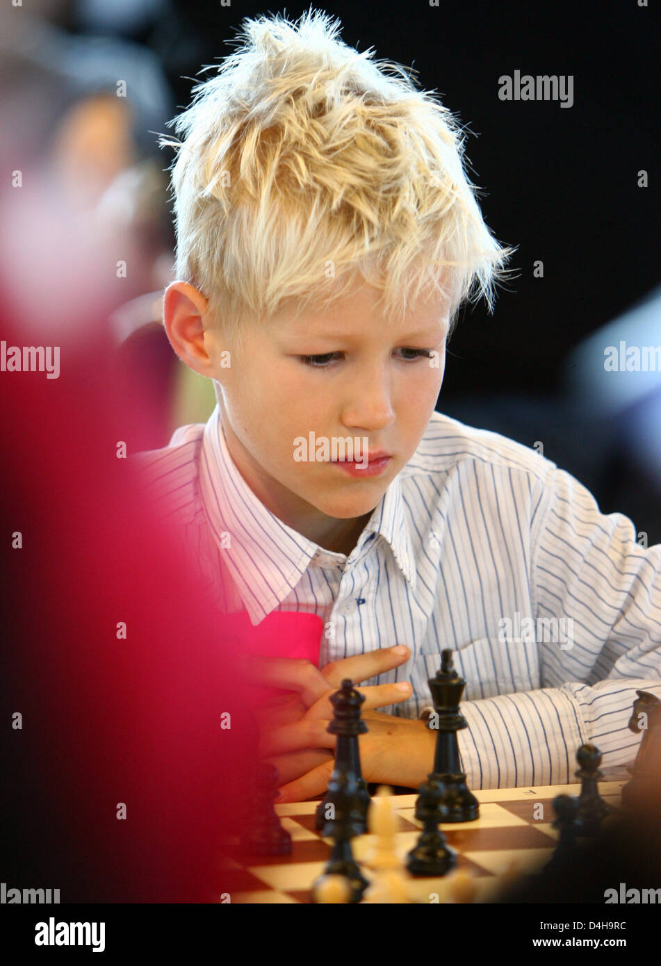 Eight-year-old Tim Wagner stands in front of ?his? poster and smiles during  the 2008 Chess Olympiad in Dresden, Germany, 15 November 2008. His is one  of the face represented during the advertisement