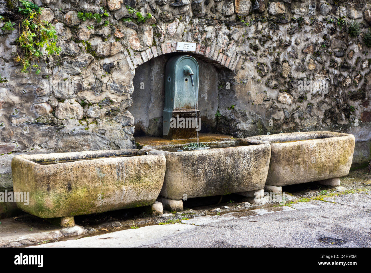 Font with three troughs and drinking water pouring from tap Stock Photo