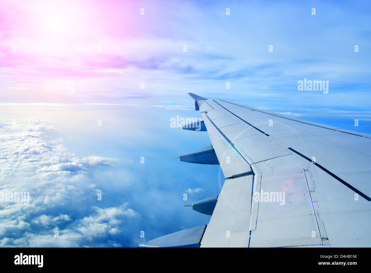 Wing of an airplane flying above the clouds Stock Photo - Alamy
