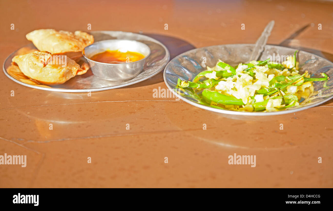 Snack of samosas, chilli dip stir fried white cabbage with fresh green chillies at greasy spoon cafe Dhabha in Gujarat India. Stock Photo