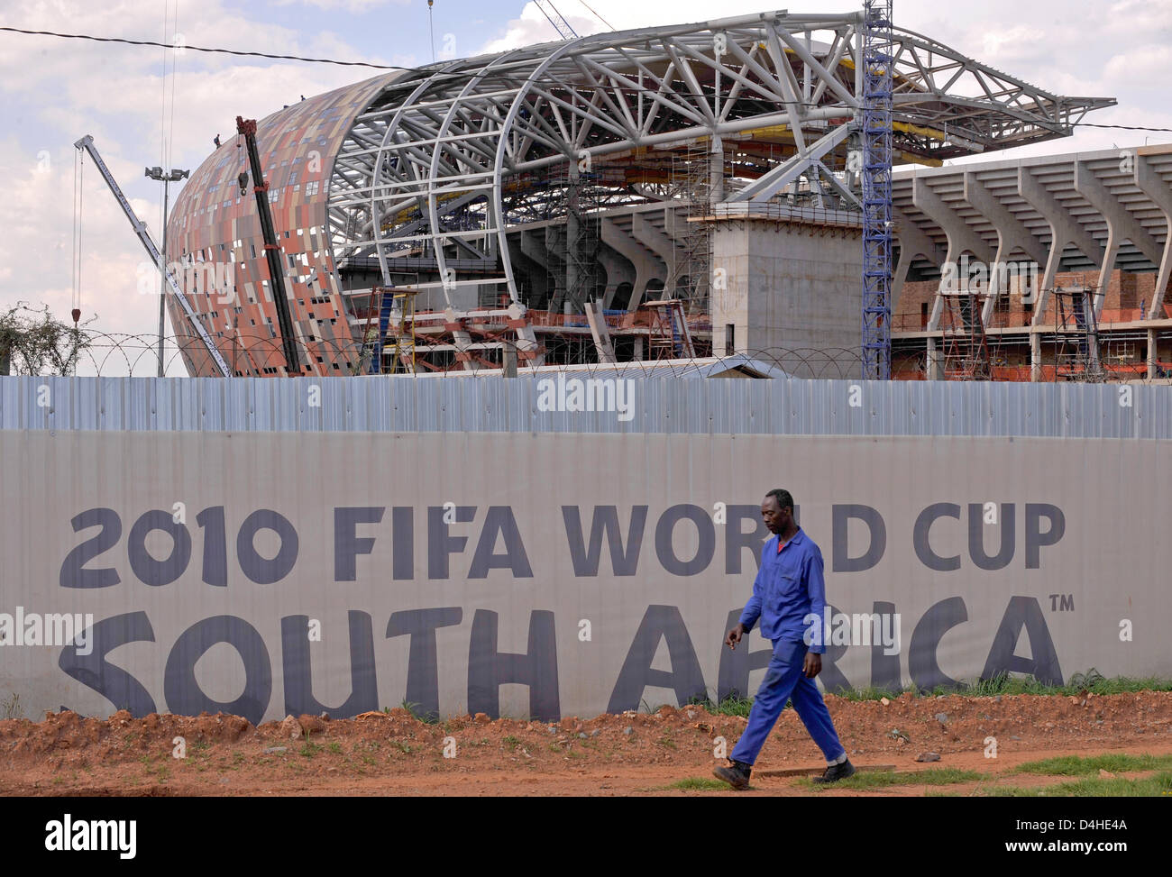 A Building Worker Passes A Banner Advertising The Fifa Soccer