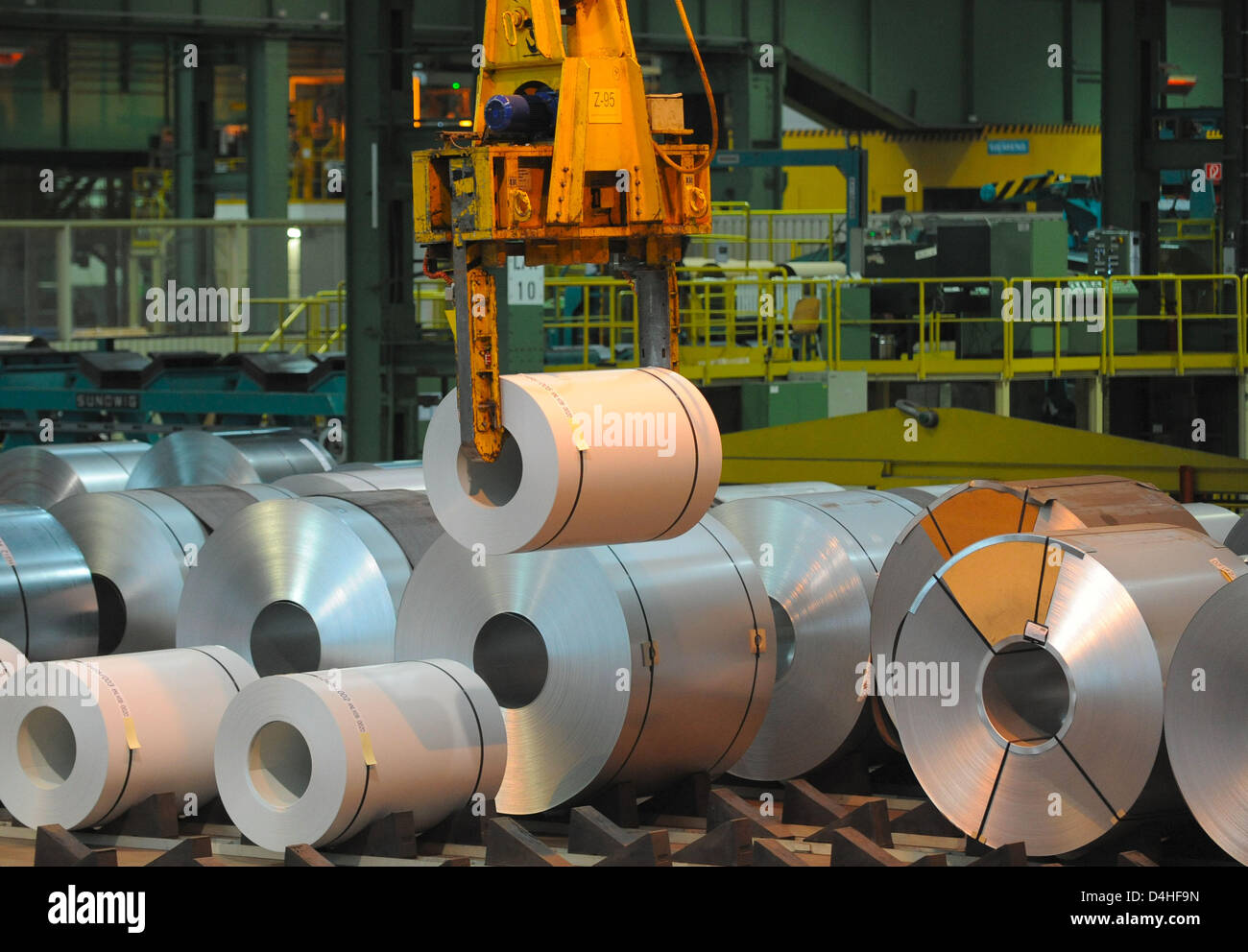 Automatic cranes transfer steel coils at a company warehouse of