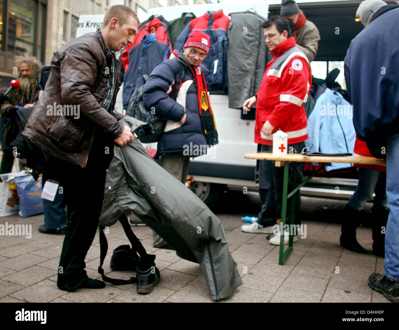 Homeless persons have a warm meal in downtown Hamburg, Germany, 09 January 2009. At freezing temperatures, German Red Cross has distributed warm food and clothes to indigent. Photo: KAY NIETFELD Stock Photo