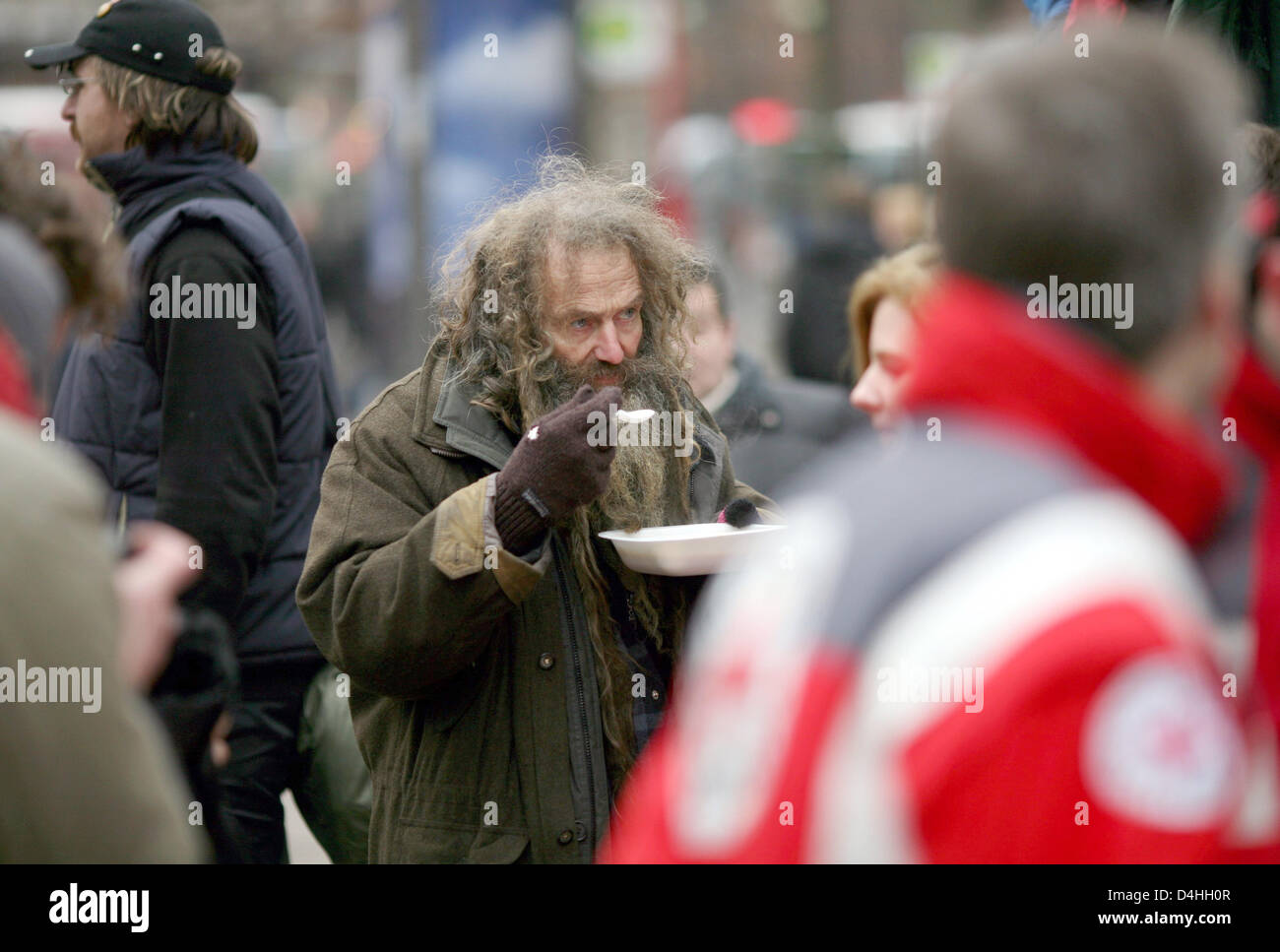 A homeless person has a warm pea soup in downtown Hamburg, Germany, 09 January 2009. At freezing temperatures, German Red Cross has distributed warm food and clothes to indigent. Photo: KAY NIETFELD Stock Photo