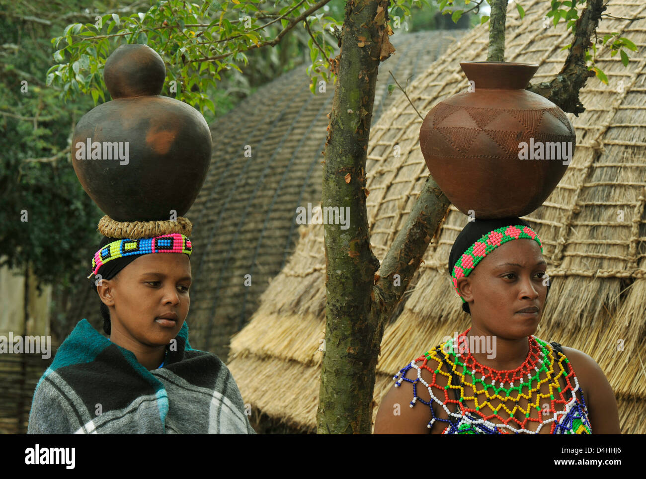 People, 2 maidens, two young Zulu woman in tradition clothes balancing clay pots on head, Shaka land, South Africa, ethnic, culture, friends Stock Photo
