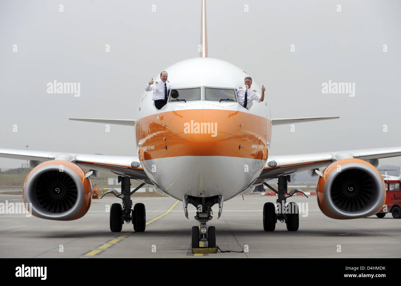 Captain Erik Olsen (R) and First Officer Sebastian Franz (L) give thumbs up out the cockpit of Boeing 737-800 ?Albert Ballin? of German tourism group Hapag-Llyod on the airport of Hamburg, Germany, 27 January 2009. Hapag-Lloyd offers a special kind of travel with luxury airplane ?Albert Ballin? that invites to a ?Cruise above the clouds?. A journey with the plane features German-sp Stock Photo