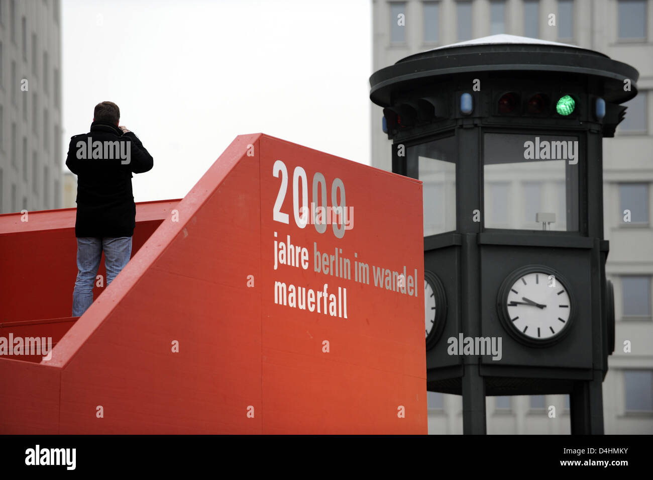 A man stands on a red, mobile viewing platform errected within the scope of the 20th anniversary celebrations of the fall of the wall (?20 Jahre Mauerfall - Berlin im Wandel?) on Potsdam Square in Berlin, Germany, 29 January 2009. Underneath the platform a small exhibition displays photos and other information about the locations in their various states before and after the fall of Stock Photo