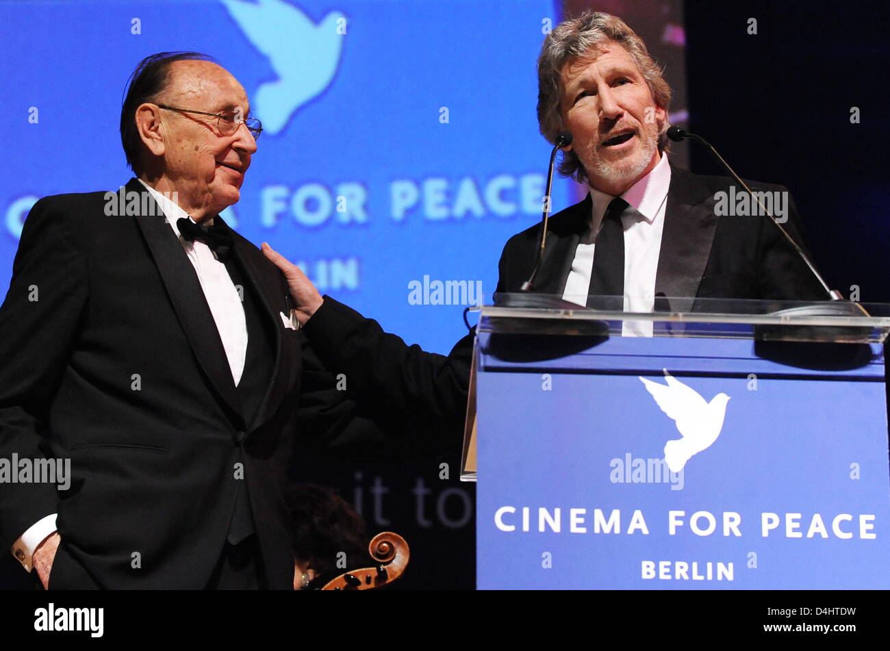 Pink-Floyd bassist Roger Waters (R) speaks next to former German Foreign Minister Hans-Dietrich Genscher at the ?Cinema for Peace? gala at the 59th Berlin International Film Festival in Berlin, Germany, 09 February 2009. ?Cinema for Peace? is a worldwide initiative promoting humanity through film. Members of the international film community have created a platform for peace and tol Stock Photo
