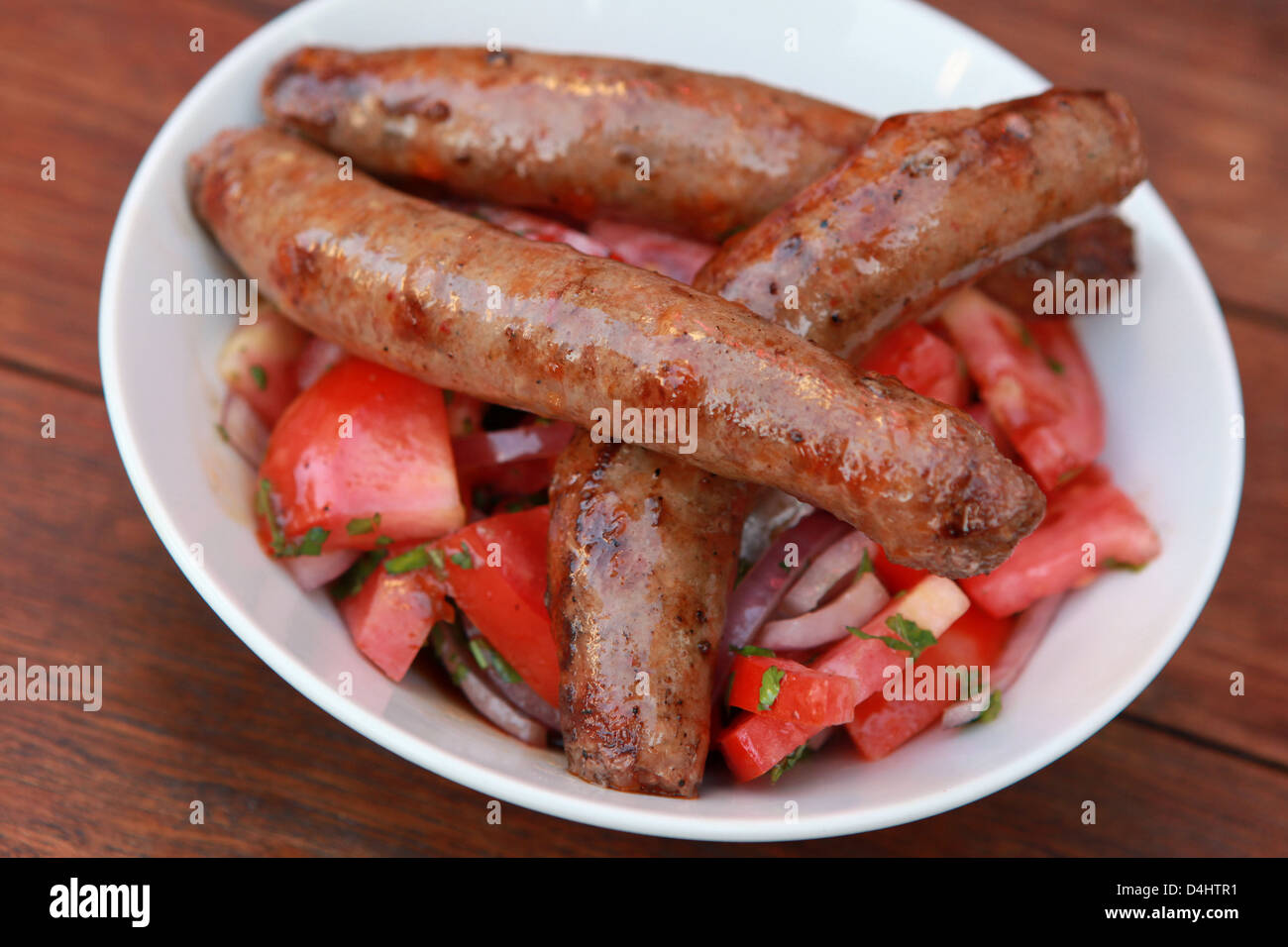 Char Grilled Merguez sausages with salad Stock Photo