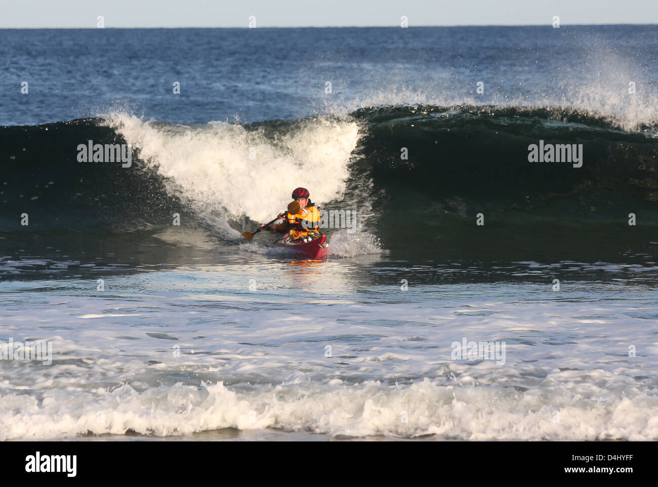 Kayak surfer coming out from the crest of a big wave in rough sea of Nova Scotia coast, Canada Stock Photo