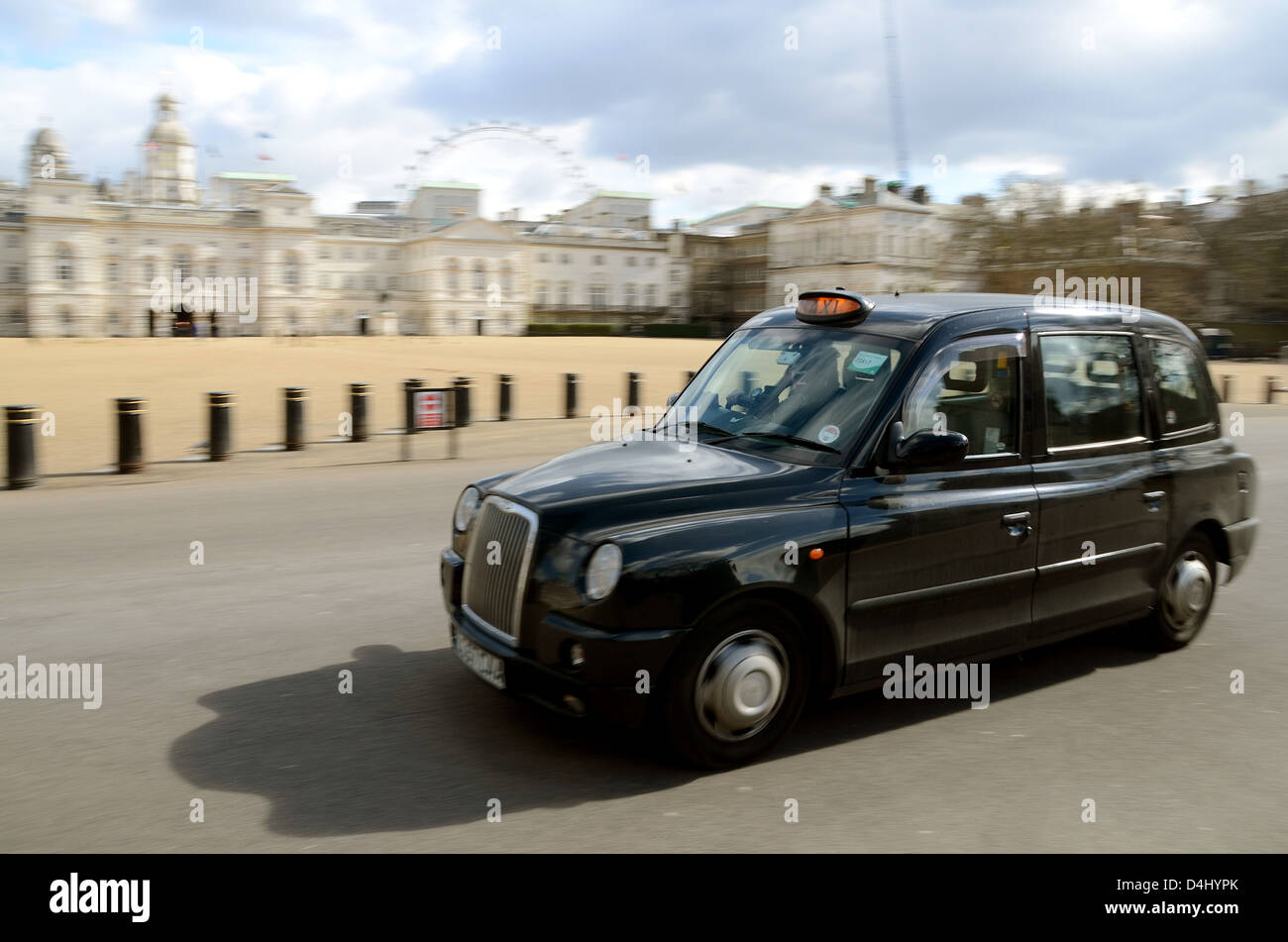 A black London taxi cab passes Horse Guards Parade at motion blur speed. British icon Stock Photo