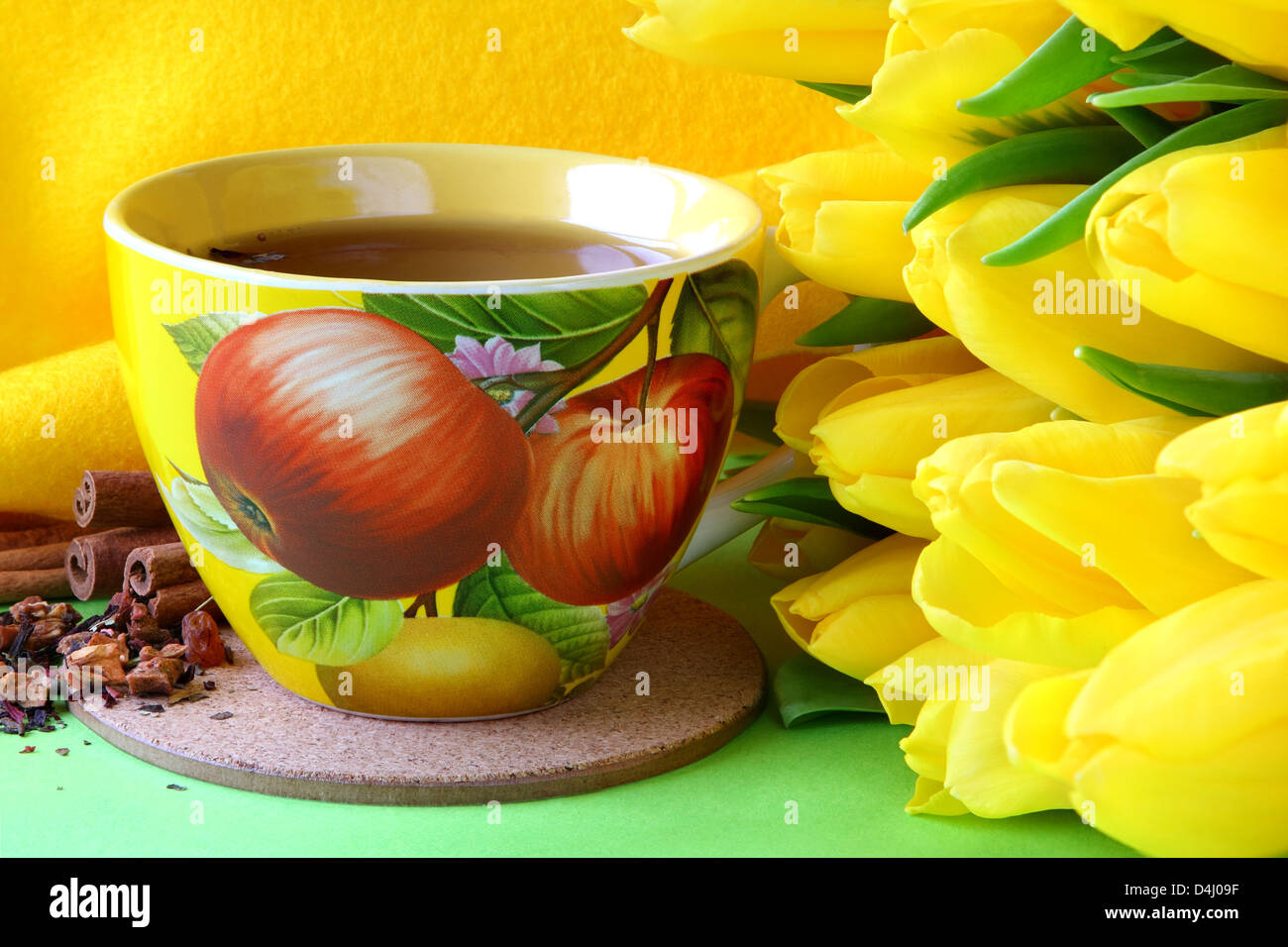 Tea cups and yellow tulips on green background Stock Photo Alamy