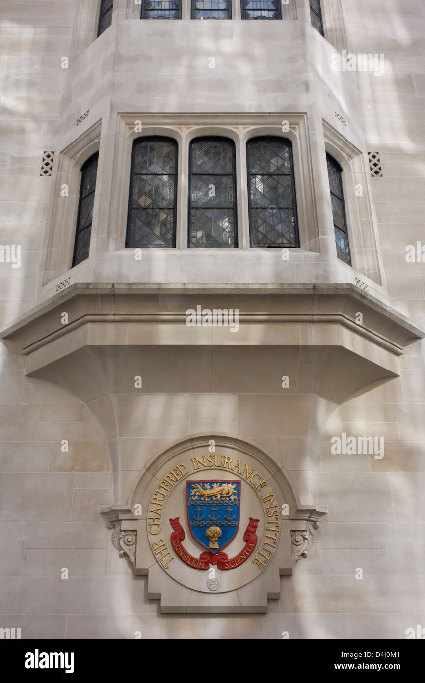 The crest of the Chartered Insurance Institute on Aldermanbury Street in the City of London. The CII is the world's leading professional organisation for insurance and financial services in the City of London, the capital's financial district - also known as the Square Mile. The institute has 102,000 members are committed to maintaining the highest standards of technical competence and ethical conduct. Below the crest that includes the representation of corn or wheat and ships' anchors are the Latin moto Consilium Scientia which translates as 'counsel and knowledge'. Stock Photo