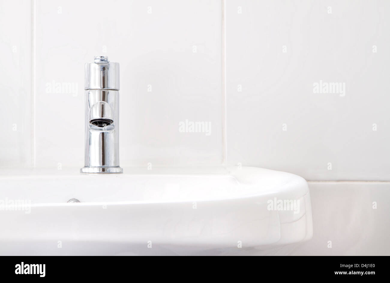One tap on white bathroom basin with white tiles Stock Photo
