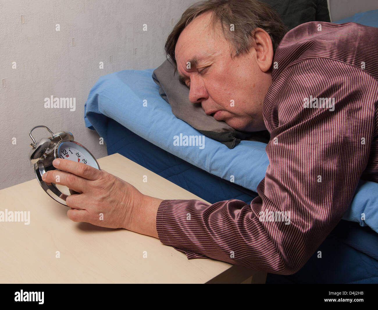 The old man has difficult to wake up in the morning. Stock Photo