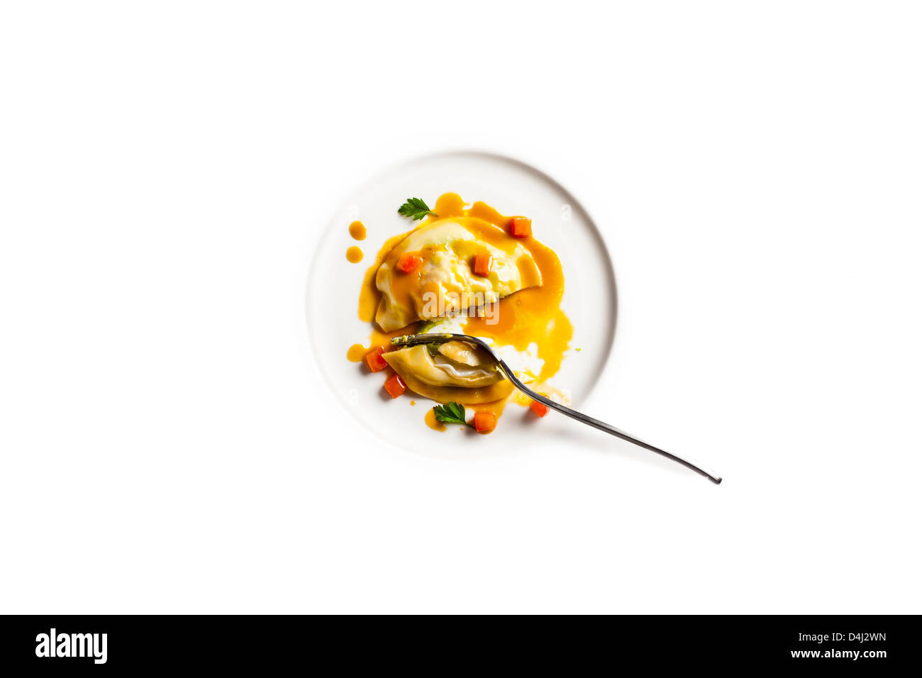 Raviolo filled with fresh peas and langoustine, served with langoustine Bisque and tomato concasse'. Stock Photo