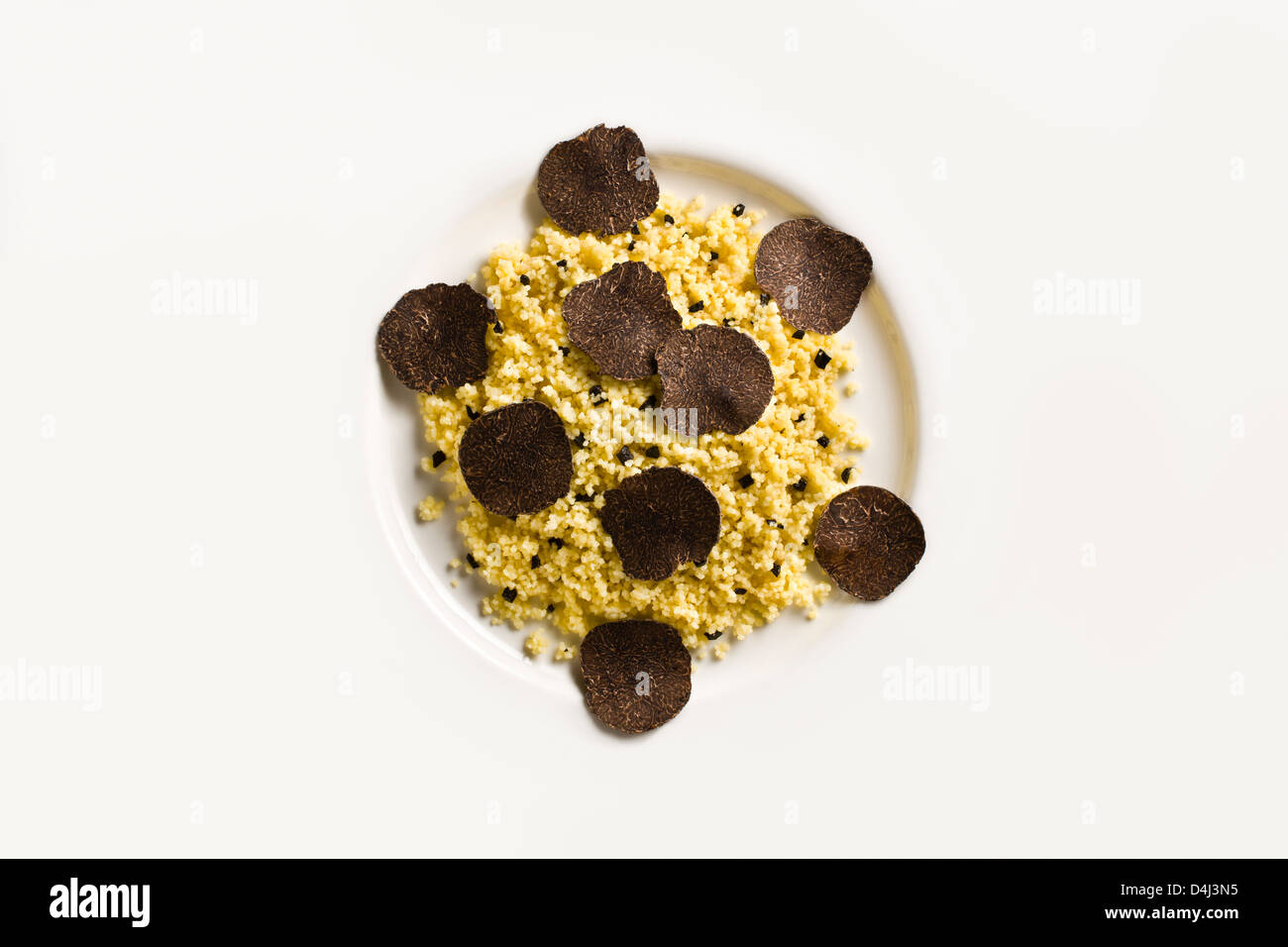 Cous Cous with Black Truffle on a white plate. Stock Photo