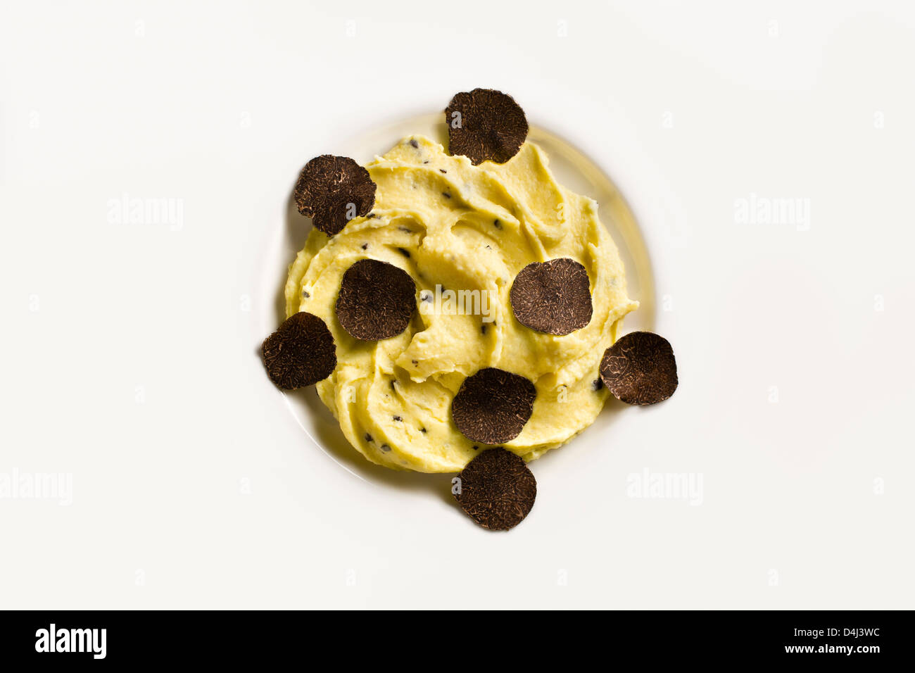 Potato purée with Black Truffles on a white plate. Stock Photo