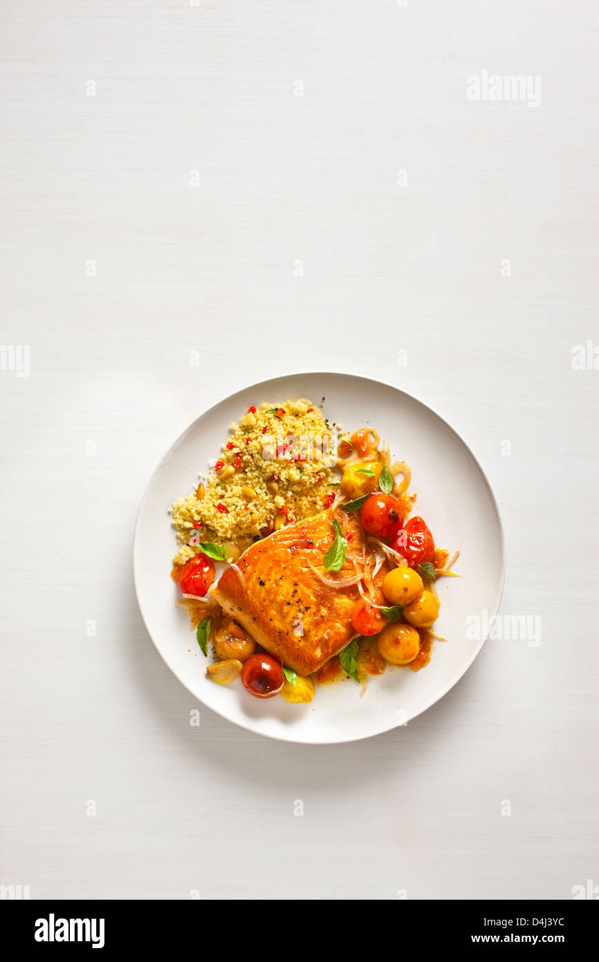 Arctic Char with Blistered Cherry Tomatoes, with Sweet Pepper Couscous with Pine Nuts Stock Photo