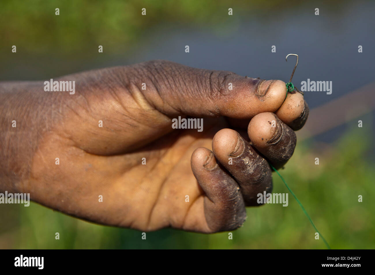 African boys fishing hook at Kubatsirana Farm run by a charity who help provide food and work, Mozambique. Stock Photo