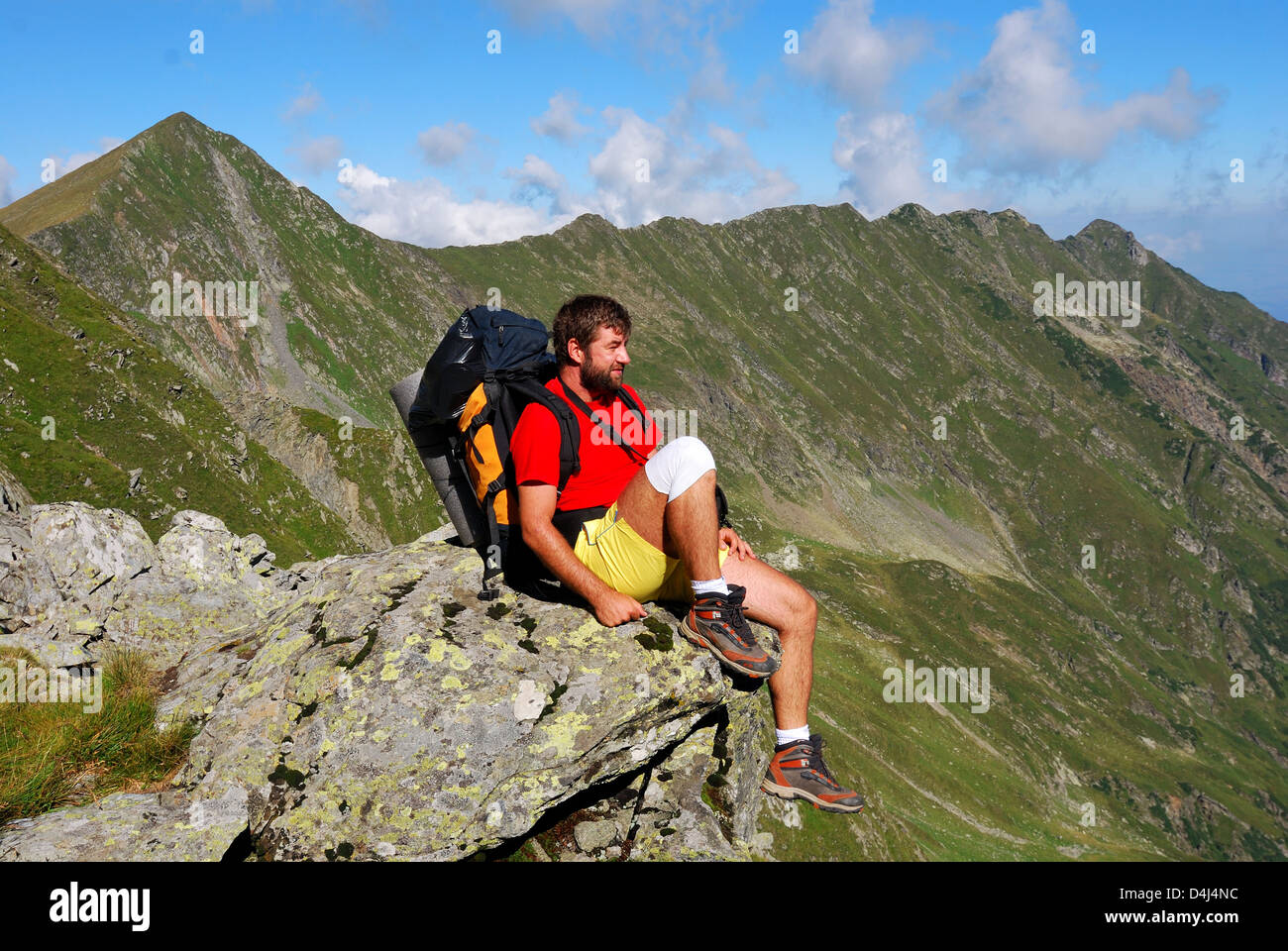 Tourist in Fagaras, Carpathian Mountains range in Romania. Outdoors scenery of hiking. Stock Photo