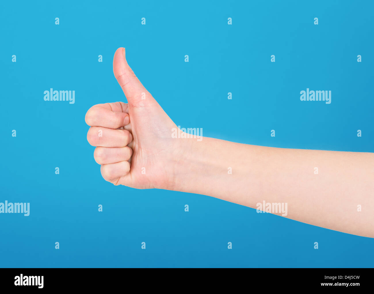 Right hand showing thumb up on blue background Stock Photo
