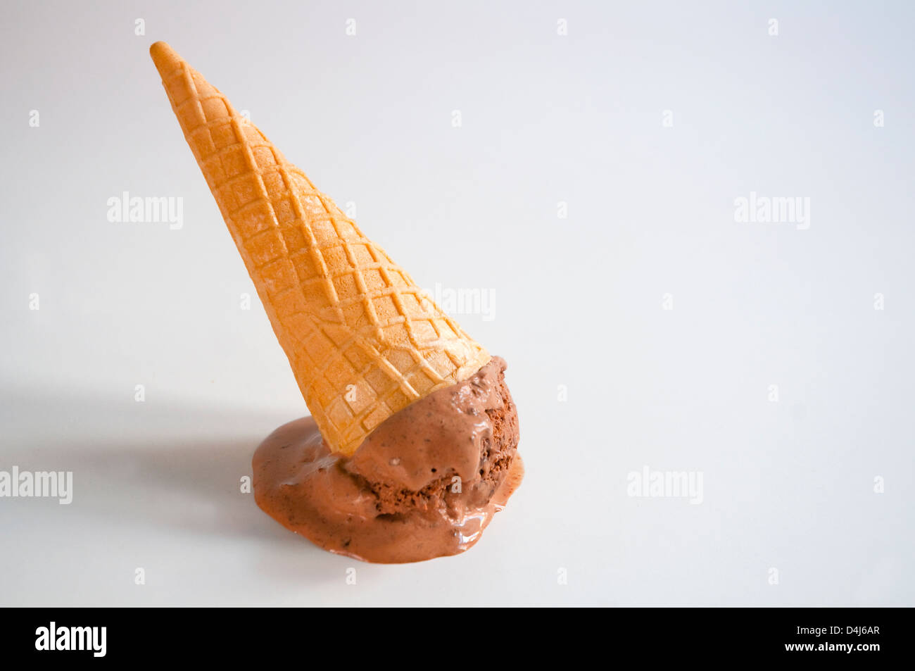 Cone of chocolate ice cream turned upside down. Stock Photo
