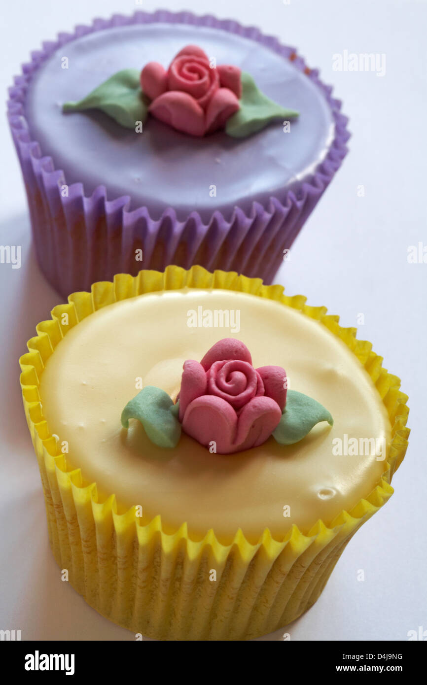 Two pastel fairy cakes, one lemon, one lilac set on white background Stock Photo