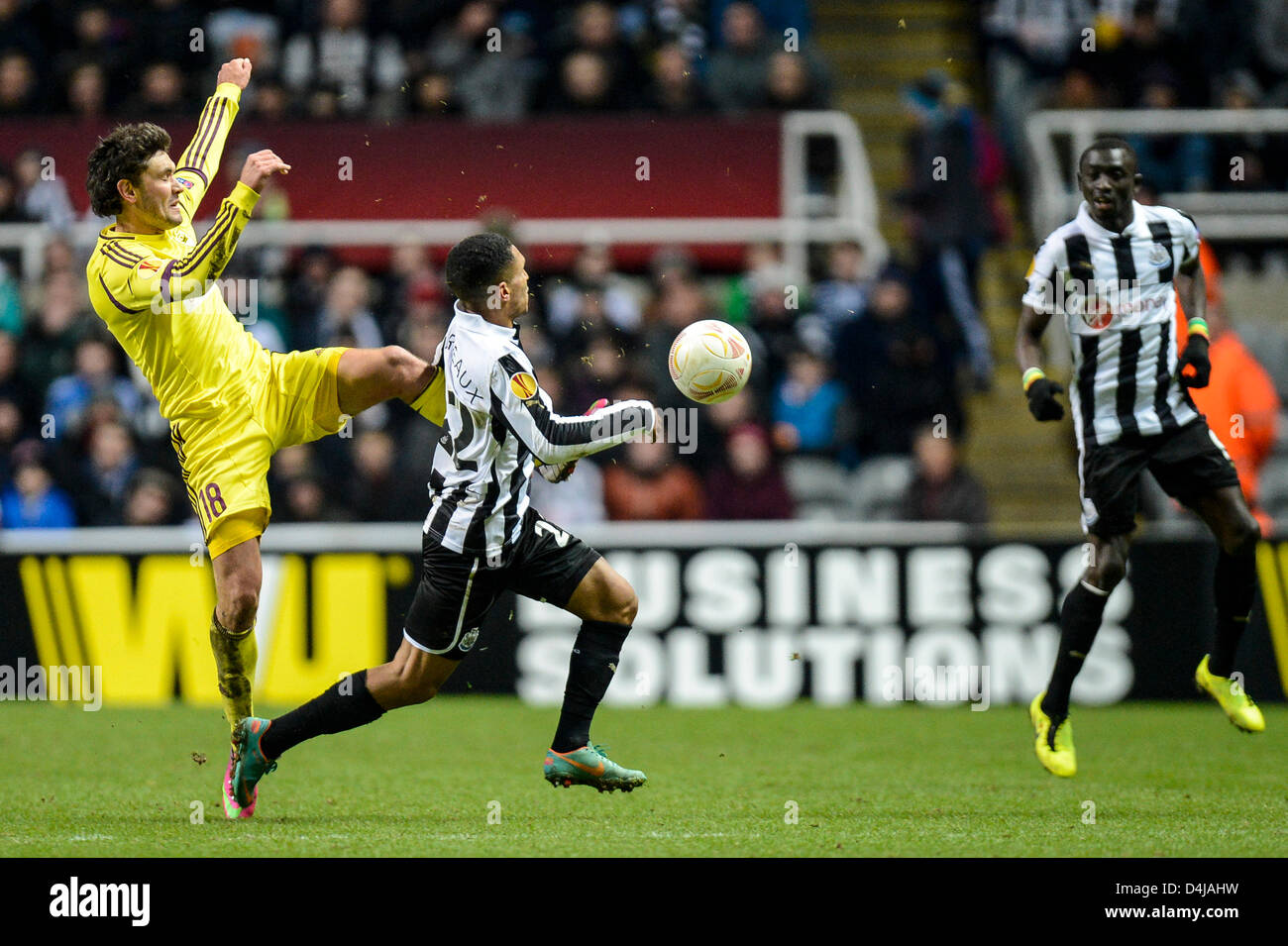 14.03.2013 Newcastle, England. Anzhi Makhachkala's Yuri Zhirkov makes a high tackle on Newcastle's Sylvain Marveaux and get's booked in action during the Europa League game between Newcastle and Anzhi Makhachkala from St James Park. Stock Photo