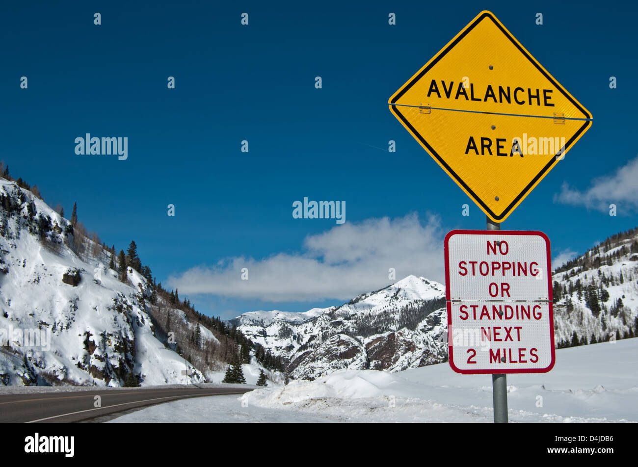 Avalanche Area Sign; A convertible sign alerts winter travelers to possible snow slides in the Rocky Mountains of southwest Colorado. Stock Photo