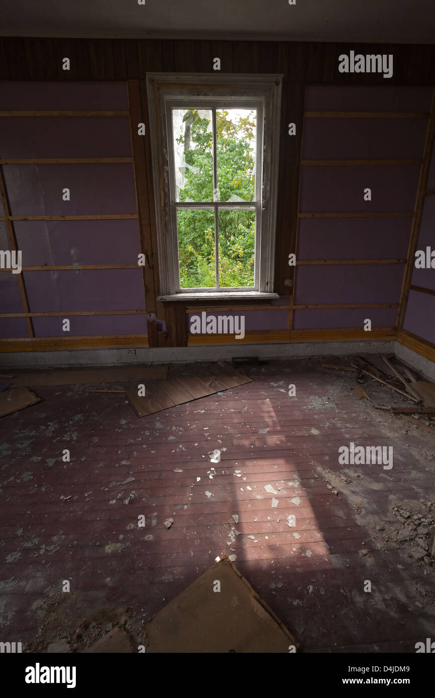 A window in an abandoned house with sunlight streaming through. Stock Photo