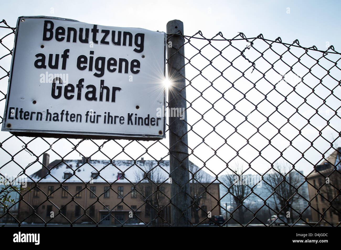 A sign saying 'Benutzung auf eigene Gefahr' ('use at your own risk') is pictured at the fence of a home for asylum seekers in Würzburg, Germany, 14 March 2013. In March 2012 ten Iranian asylum seekers went on a hunger strike. The protest turned into a nationwide movement. Photo: David Ebener Stock Photo