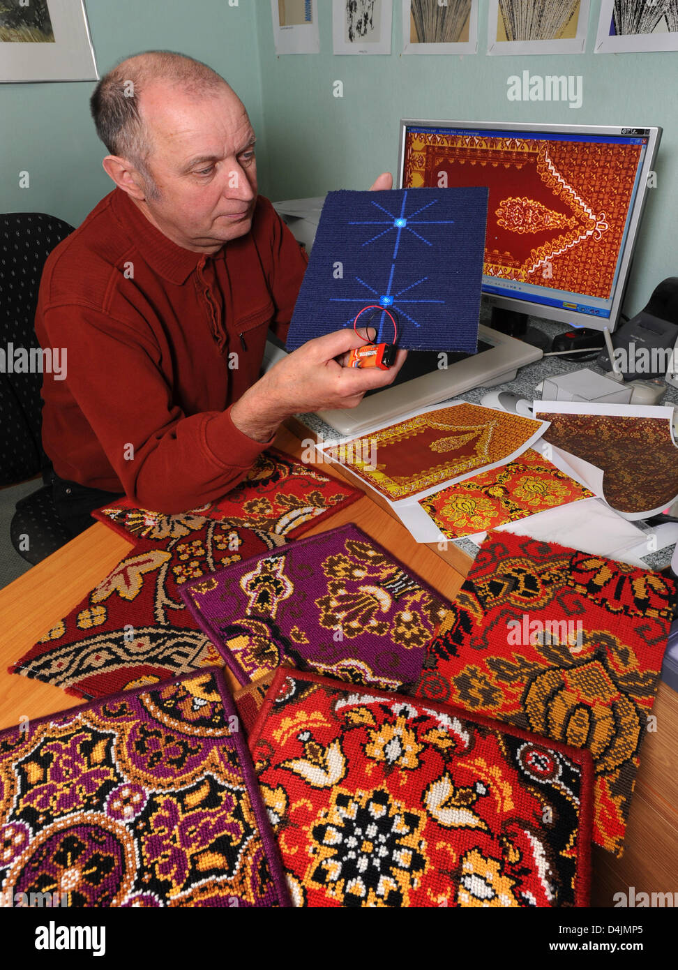 Company director Eberhard Witzschel of the Saxon Carpet Manufactory shows the first prototypes of prayer rugs equipped with GPS chips and light-emitting diodes which indicate the exact direction of Mecca for Muslims in Frankenberg, Germany, 16 February 2009. This patented idea is to be made ready for marketing in cooperation with an electronics company in North Rhine Westfalia. The Stock Photo