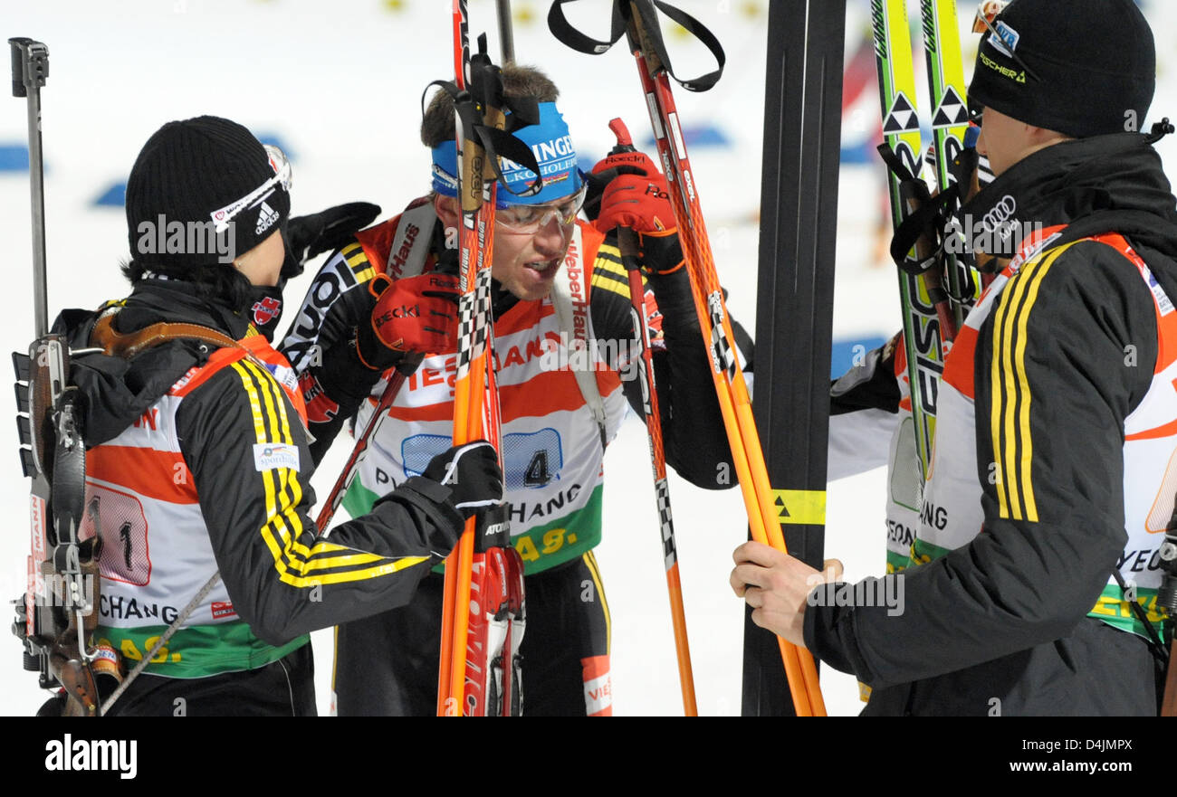 Michael Greis (2-L) exhaustedly reaches the finish line and is greeted by Arnd Peiffer, Simone Hauswald (R) and Andrea Henkel (L) after the 4x6 kilometres mixed relay competition at the Biathlon World Championships in Pyeongchang, Republic of Korea, 19 February 2009. The German team won the bronze medal. Photo: Martin Schutt Stock Photo