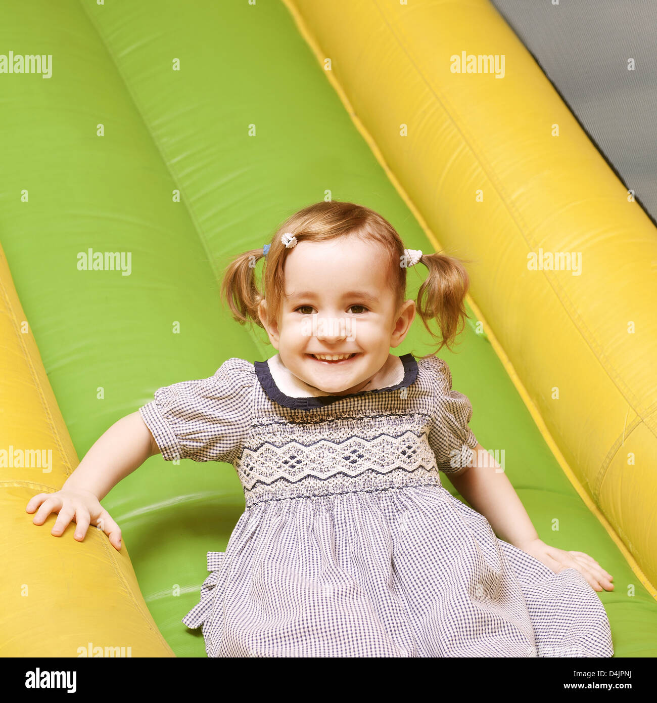 little girl on playground slide laughing Stock Photo Alamy