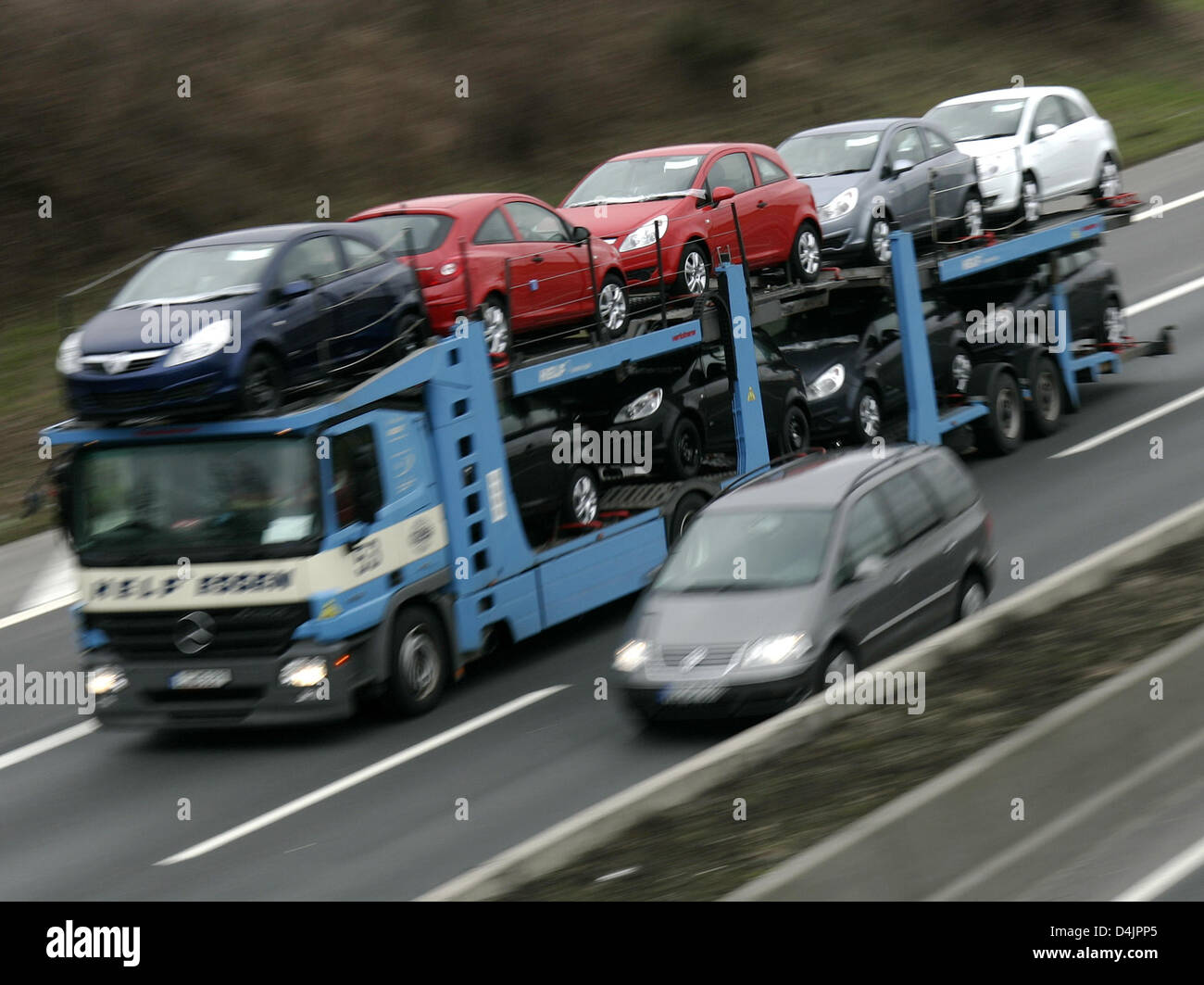 A car transporter leaves the Opel plant in Bochum, Germany, 24 February 2009. Opel?s parent company GM announced to slash 26,000 jobs outside the USA. A breakup of Opel and GM is being discussed. Photo: Roland Weihrauch Stock Photo