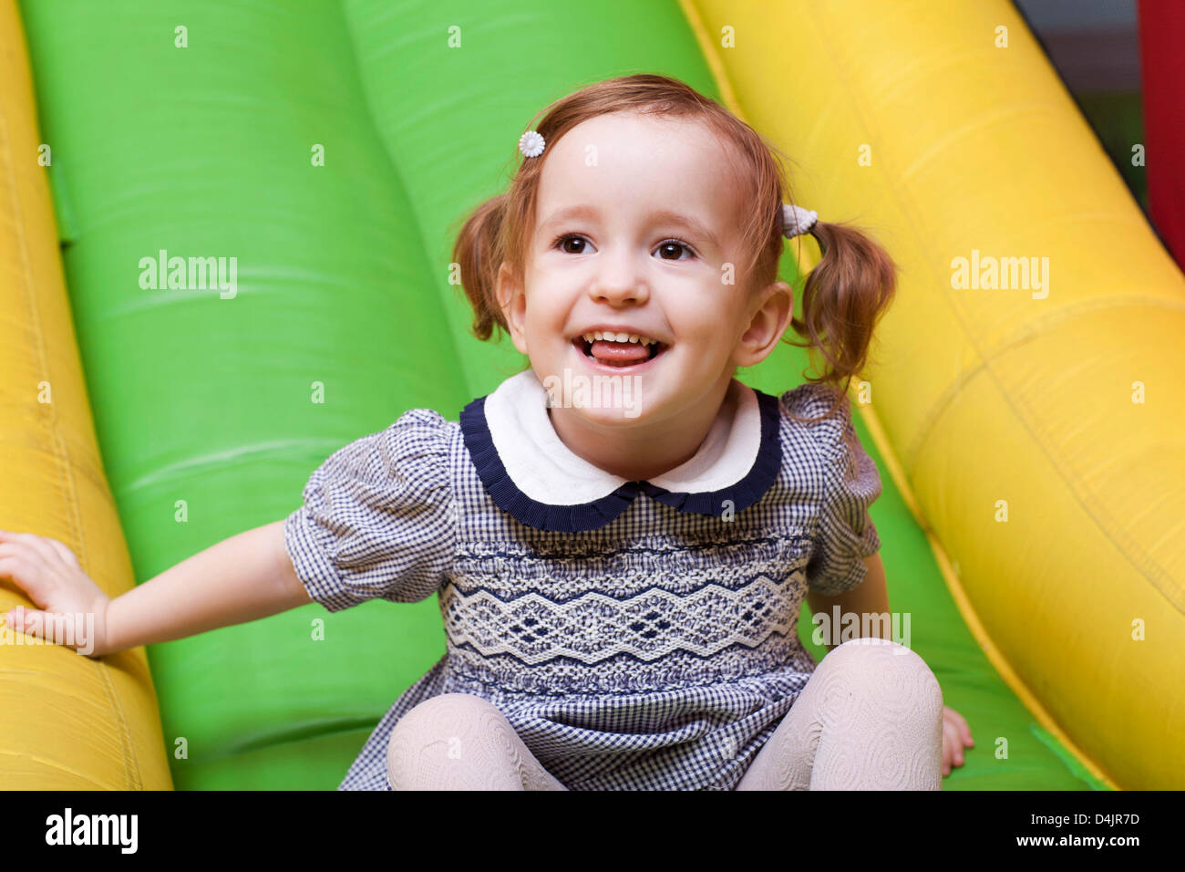 little girl on playground slide laughing Stock Photo - Alamy