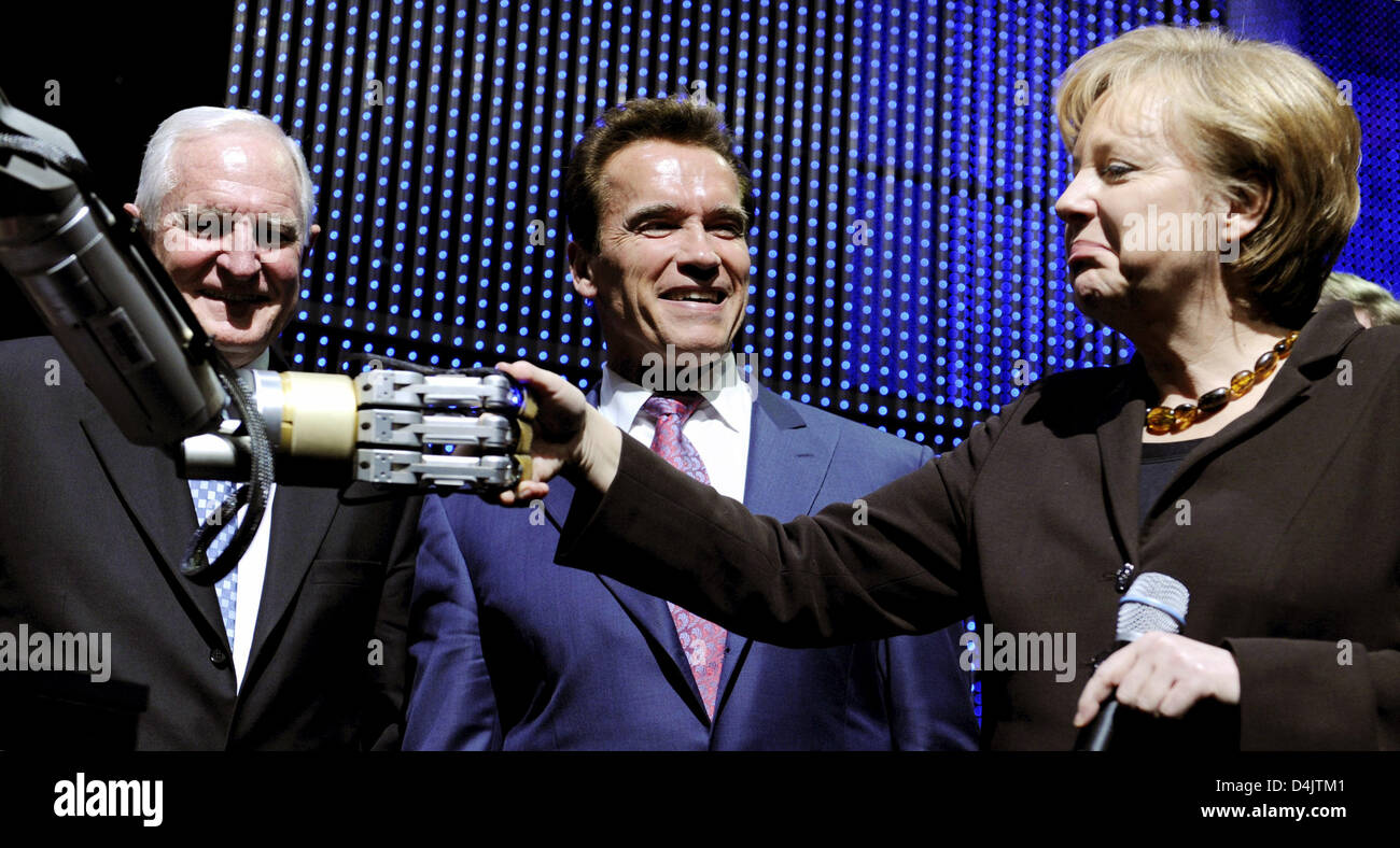 Arnold Schwarzenegger (C), Governour of U.S. state California, German Chancellor Angela Merkel (R), and Craig Barrett (L), chairman of the board of directors of Intel, shake hands with robot Marvin during the opening of CeBIT 2009 trade show in Hanover, Germany, 02 March 2009. Due to the global economic crisis the number of exhibitors for the world?s largest computer trade show dec Stock Photo