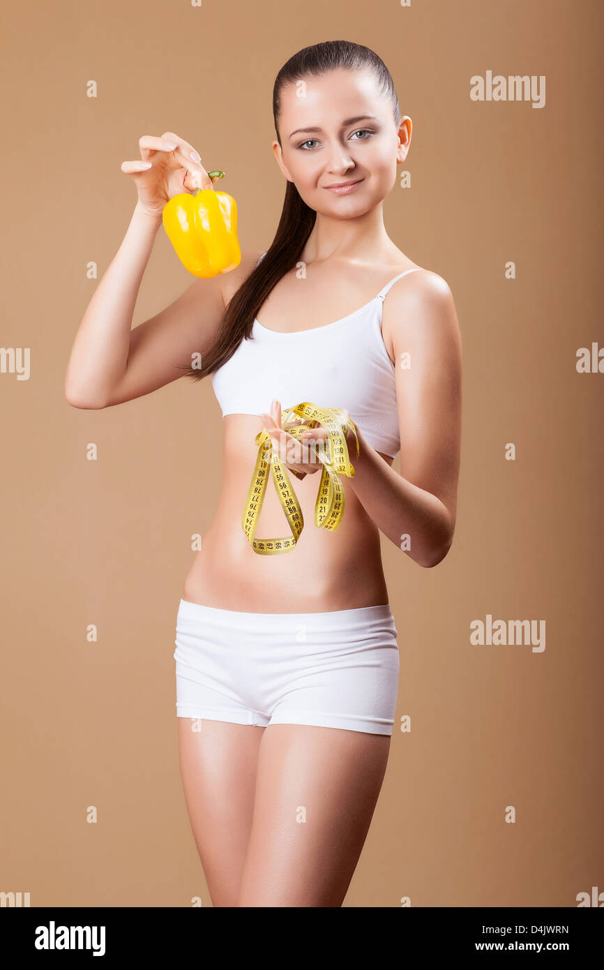 Sporty young woman with fresh pepper and measure . Concept of healthy lifestyle. Stock Photo