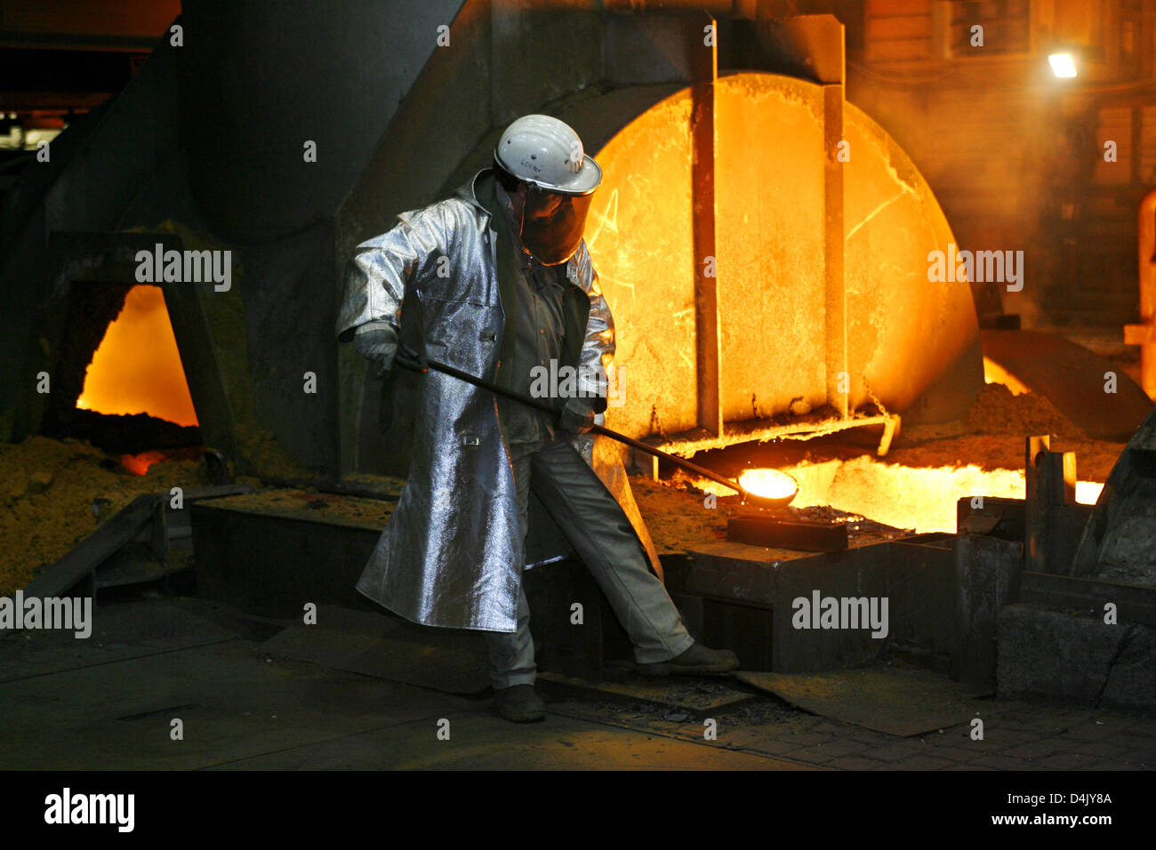 A steel worker checks the quality of steel proceeded at ThyssenKrupp in Duisburg, Germany, 02 March 2009. Pig iron is mixed with iron scrap and refined with oxygen to steel. From the steel, slabs are further proceeded to coils and thin sheets used a.o. in the car industry. Photo: Roland Weihrauch Stock Photo