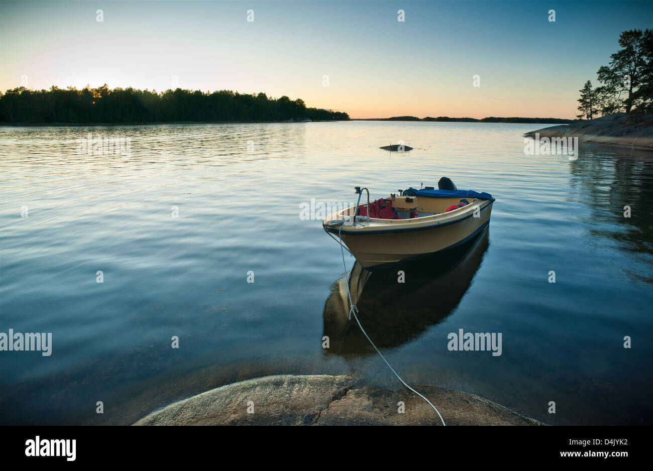 Boat docked in still lake Stock Photo