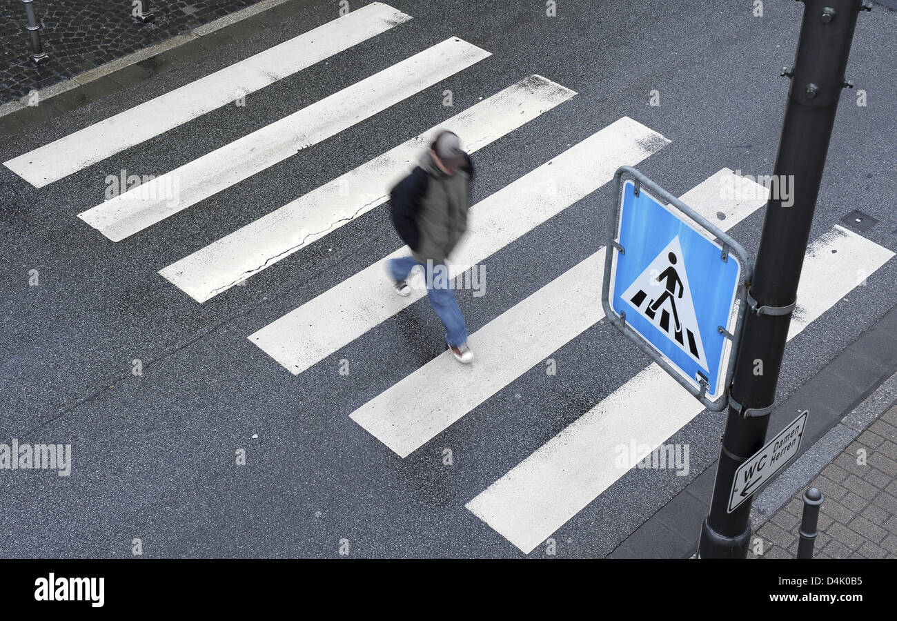 The picture shows a pedestrian walking on a zebra crossing in Heidelberg, Germany, 06 March 2009. Photo: Ronald Wittek Stock Photo