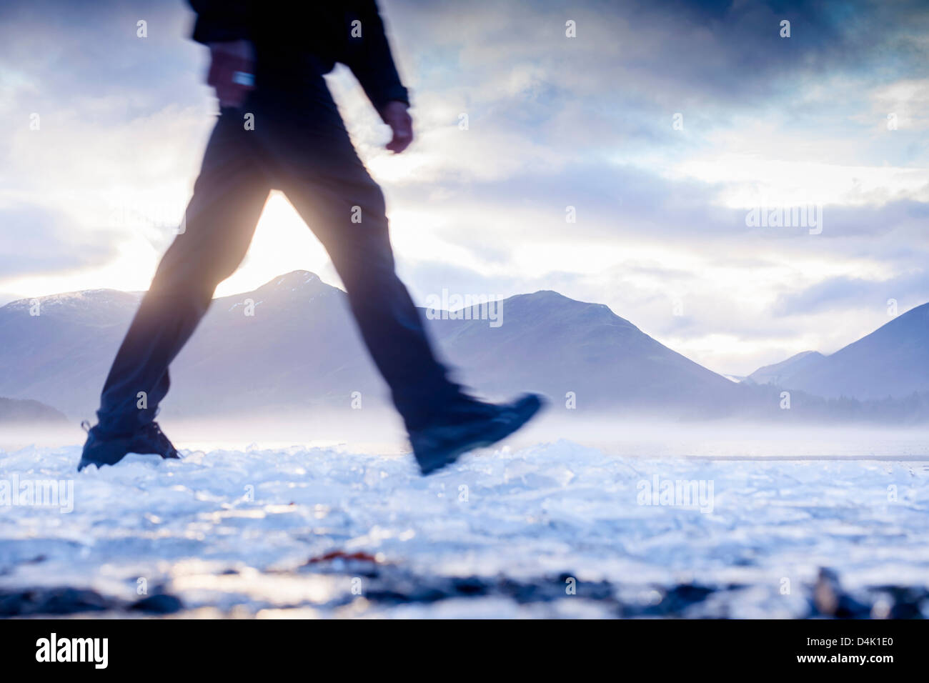 Hiker walking on ice in rural landscape Stock Photo