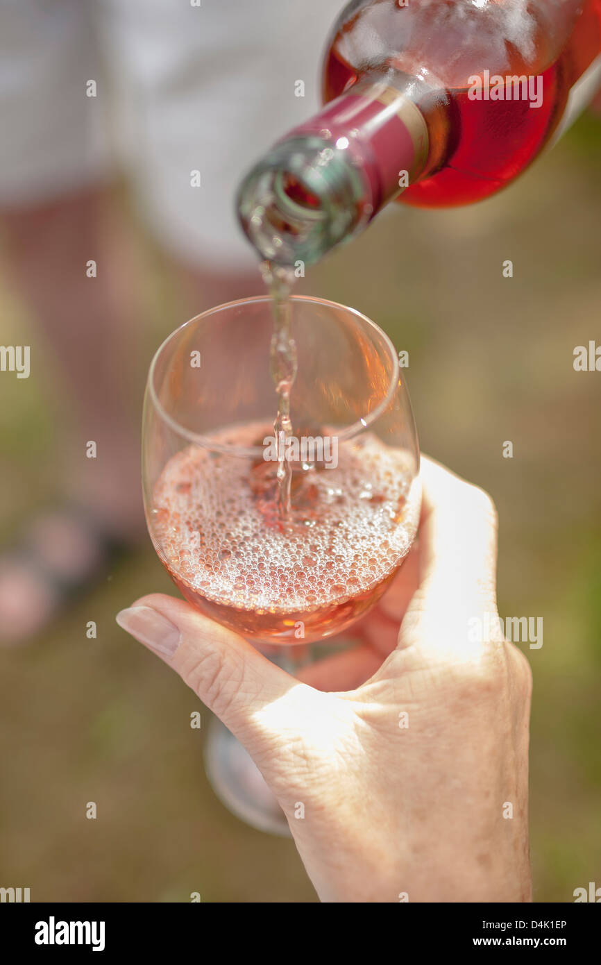 Woman pouring glass of wine outdoors Stock Photo