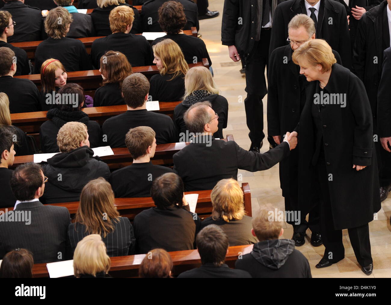 German Chancellor Angela Merkel (R) speaks to mourners before leaving the official memorial service at St. Karl Borromaeus Church in Winnenden, Germany, 21 March 2009. Behind her walks the President of the Federal Constitutional Court, Hans-Juergen Papier. Chancellor Merkel, President Koehler and other official guests attended the act of state to commemorate the 15 vicitims killed  Stock Photo