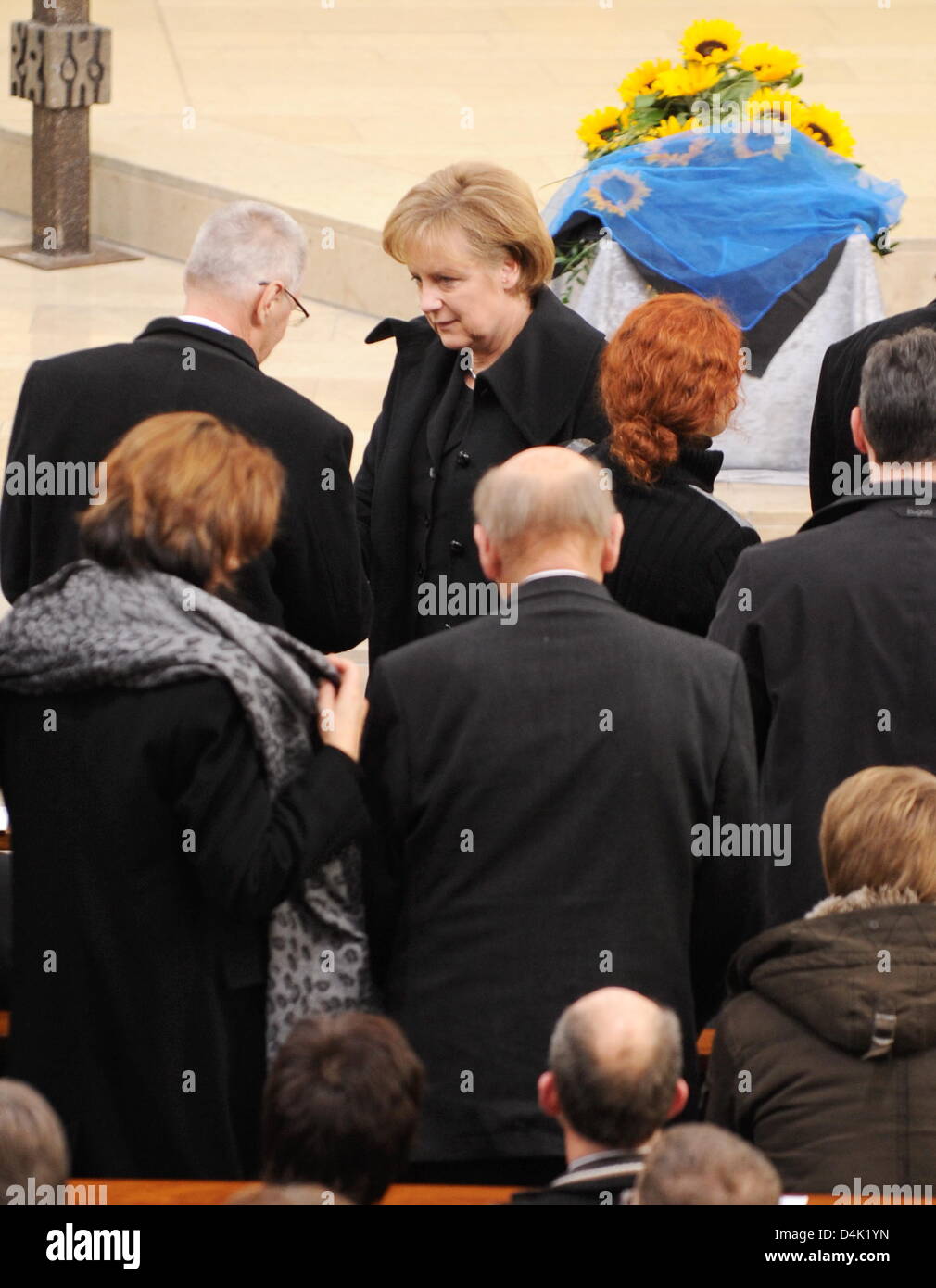 German Chancellor Angela Merkel (C) speaks to mourners before leaving the official memorial service at St. Karl Borromaeus Church in Winnenden, Germany, 21 March 2009. Behind her walks the President of the Federal Constitutional Court, Hans-Juergen Papier. Chancellor Merkel, President Koehler and other official guests attended the act of state to commemorated the 15 vicitims killed Stock Photo