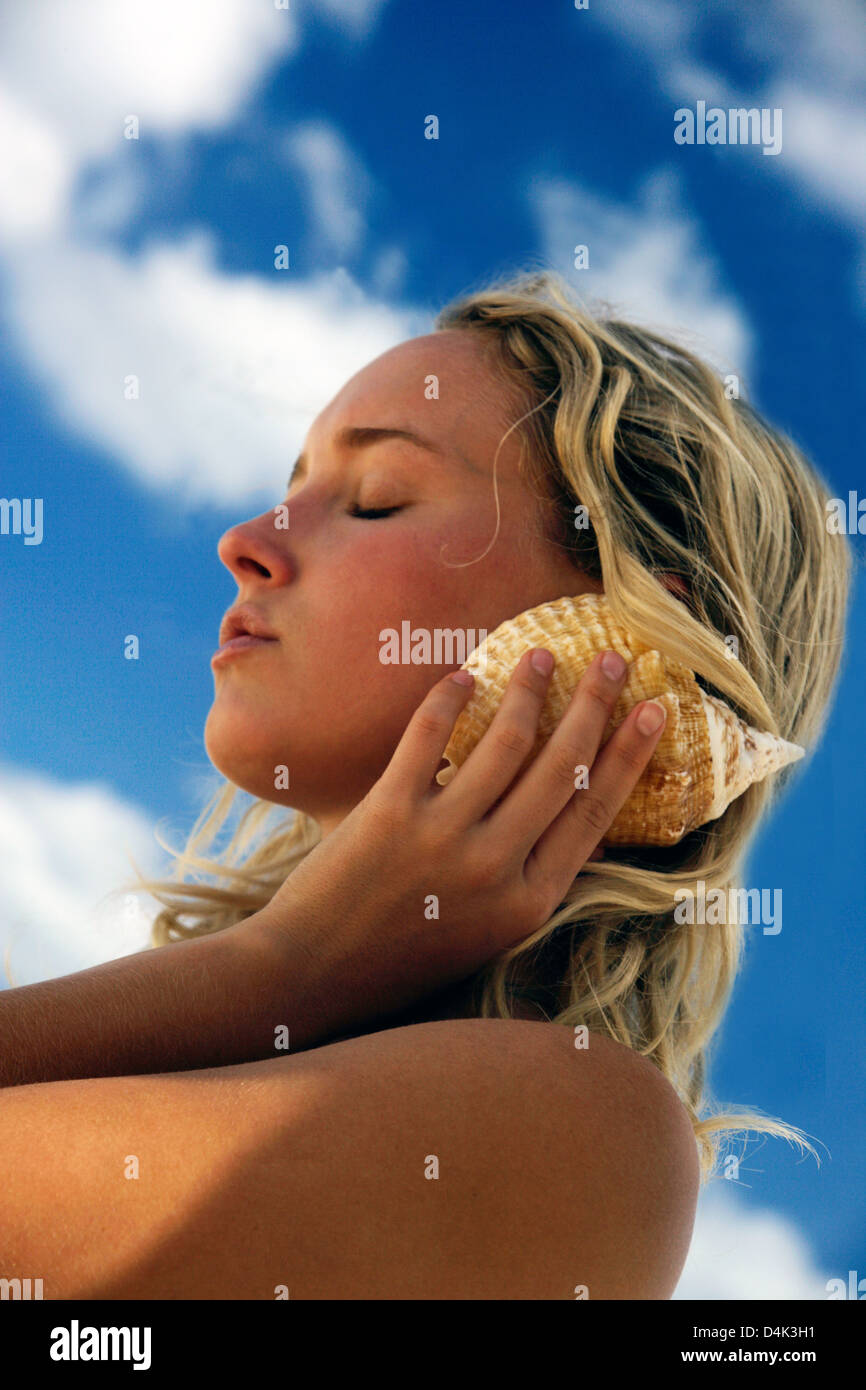 Conch shell listening hi-res stock photography and images - Alamy
