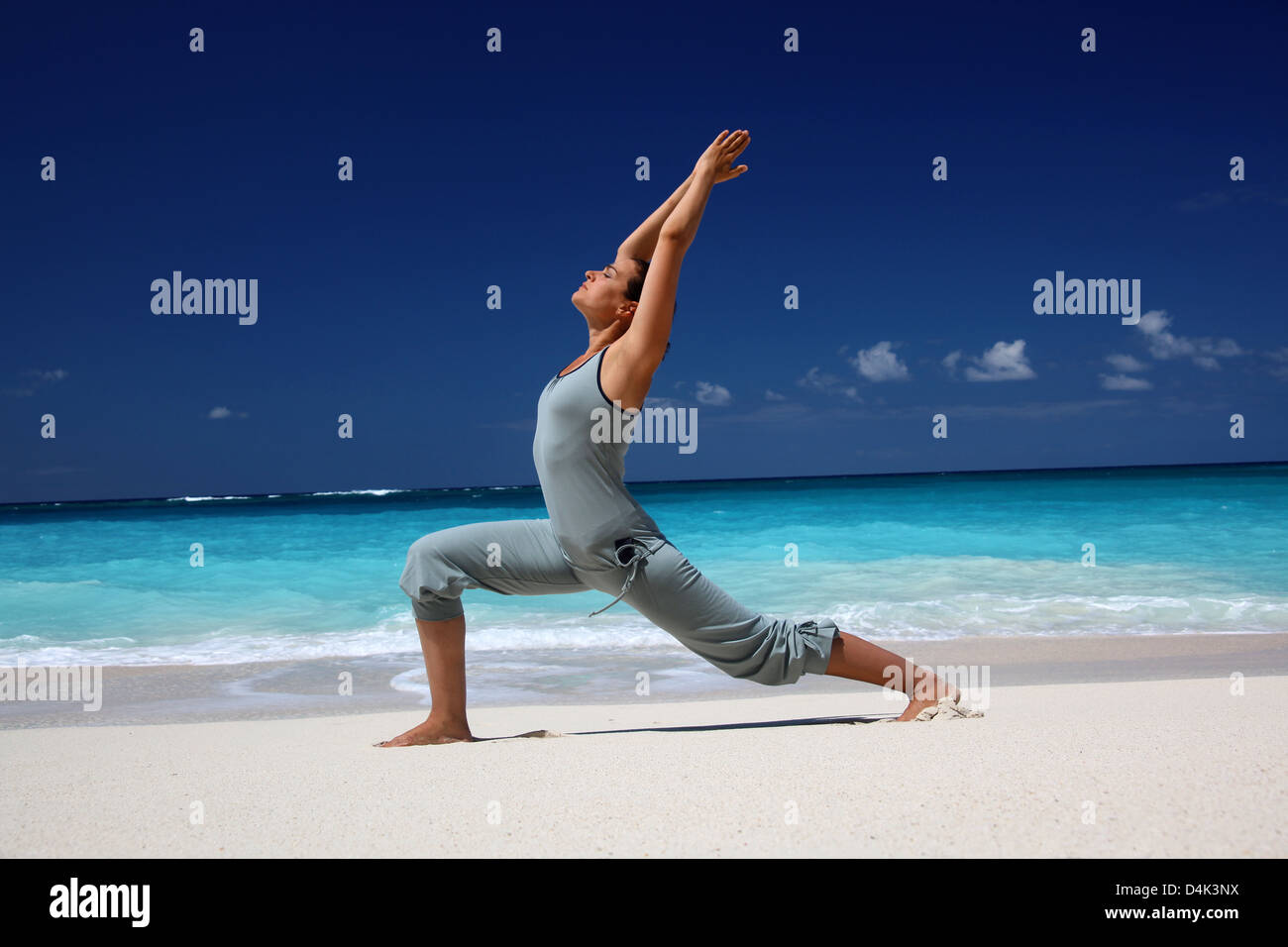 Woman practicing yoga on tropical beach Stock Photo