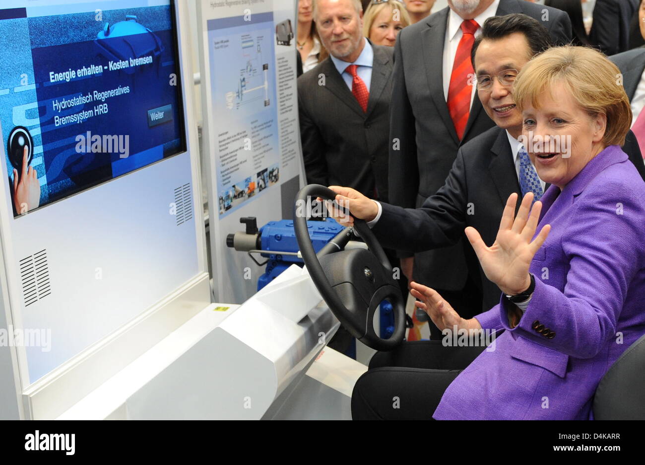 German Chancellor Angela Merkel (R) and South Korea?s Prime Minister Han Seung-Soo (2-R) pose behind the steering wheel of a lorry mockup presenting the hydrostatic regenerative brake system designed by ?Bosch Rexrodt? during their opening round tour at the Hannover Messe 2009 trade fair in Hanover, Germany, 20 April 2009. Some 6,150 companies from 61 nations showcase their latest  Stock Photo